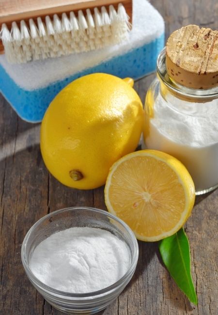 Fresh lemons, scrub brush, sponge, baking soda in a jar and clear bowl.  Save money by making your own cleaning products.  