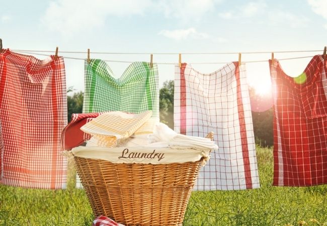 Save money by drying laundry on a clothes line with wicker basket in front